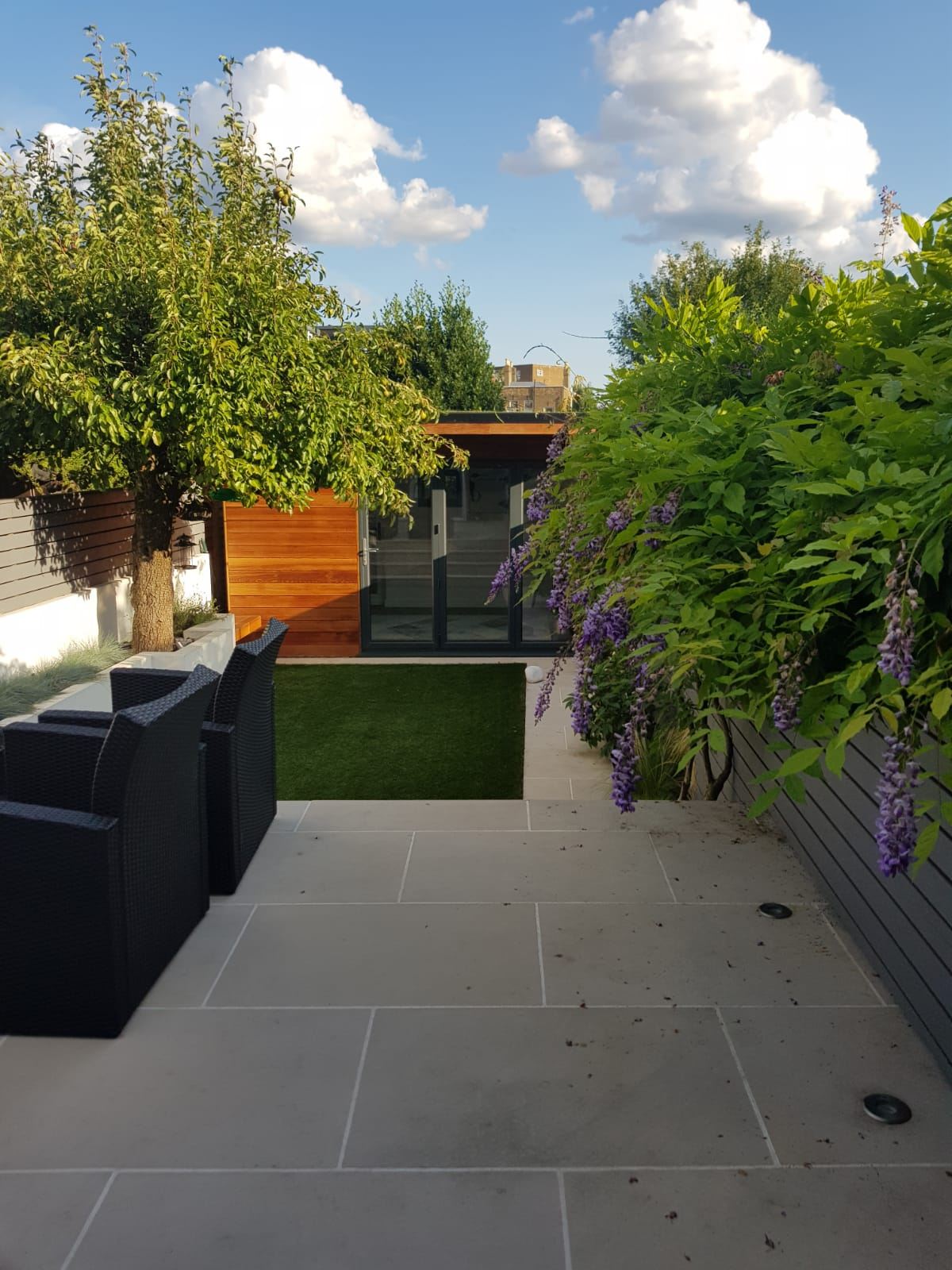 Landscaped garden after presentation: fresh lawn, limestone terrace, wisteria in bloom and a cedar garden room