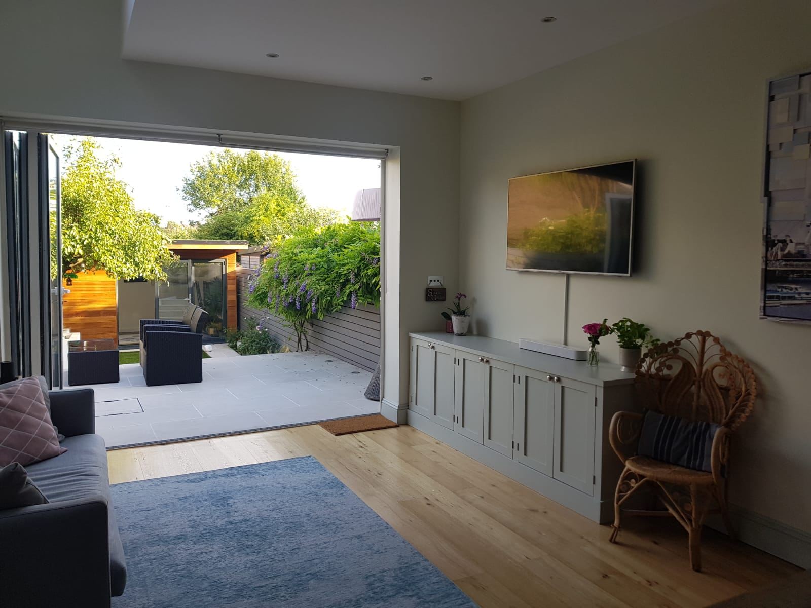Styled sitting room in soft evening light, opening onto a wisteria-lined garden terrace