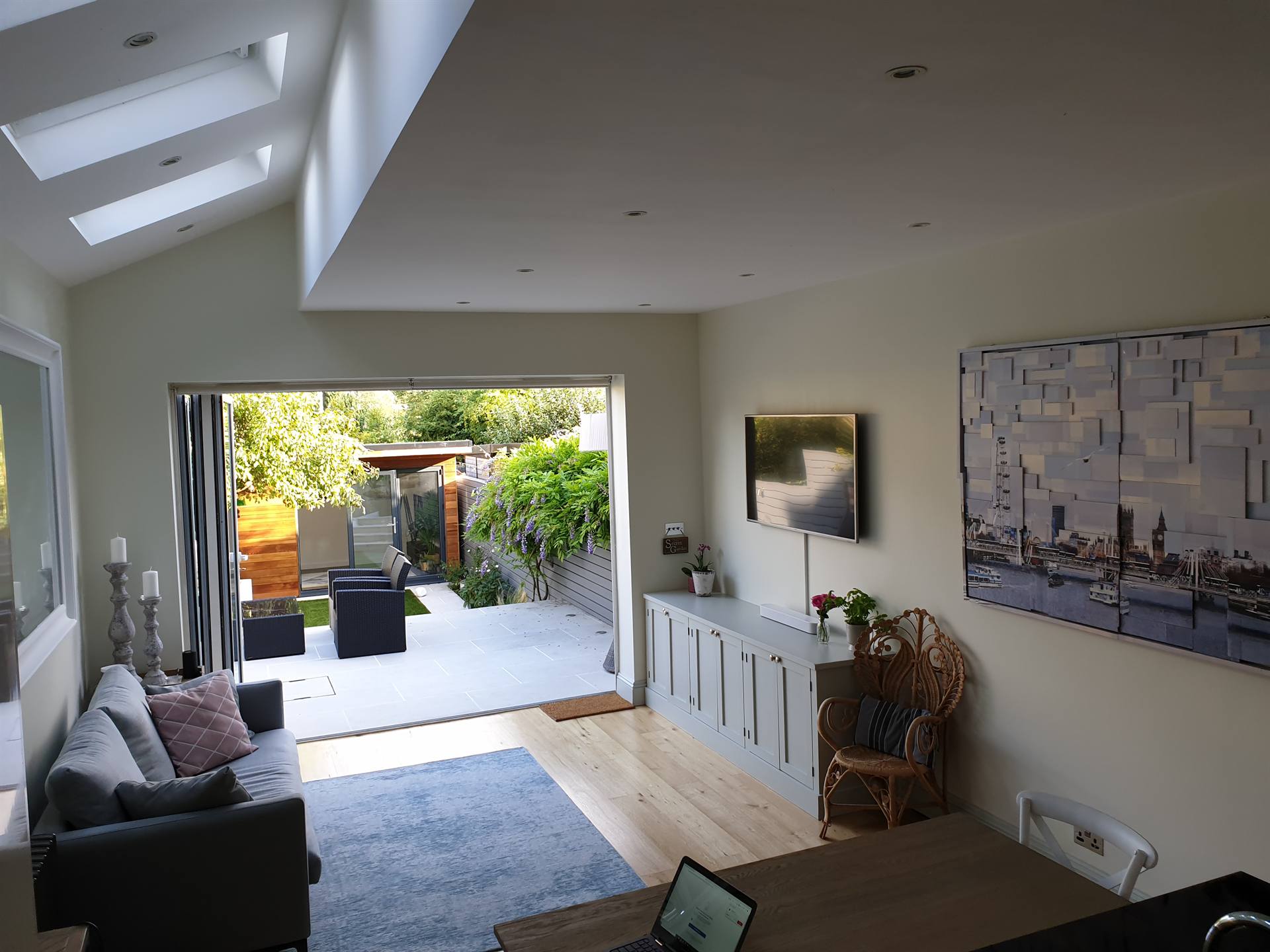 A finished Final Flourish project: bright open-plan sitting room with bifold doors onto a landscaped garden